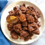 Indonesian beef rendang on a round white plate.