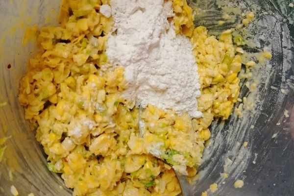 adding the flour into sweetcorn fritter mixture