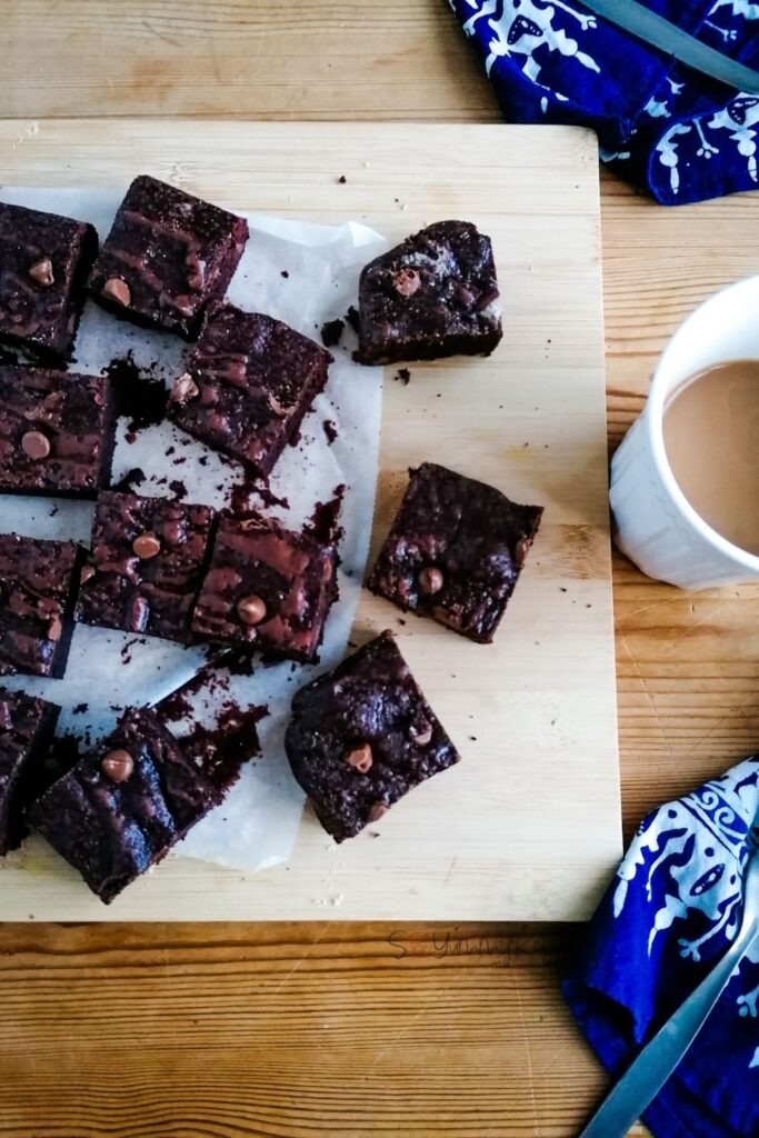 scattered pieces of dairy free chocolate brownies on a chopping board