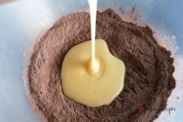 pouring the egg mixture into the flour and cocoa mixture