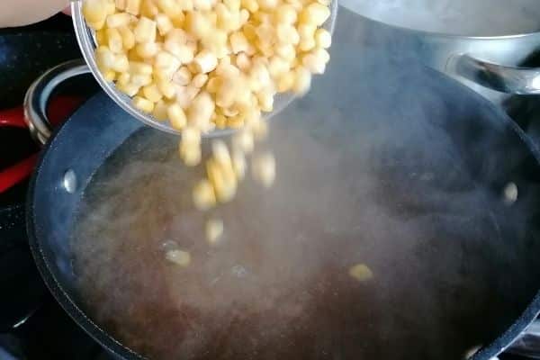 Adding sweetcorn to the chicken soup