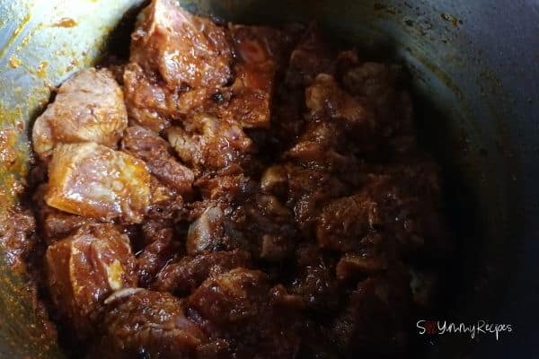 frying the lamb meat pieces in the masala base sauce
