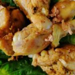 Indonesian fried chicken pieces on a lettuce