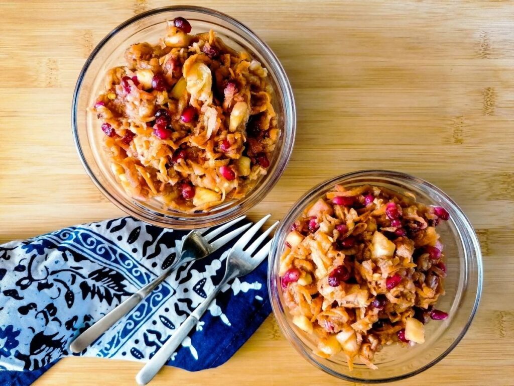 two bowls of Indonesian sweet potato slaw, a blue batik napkin, and two small forks