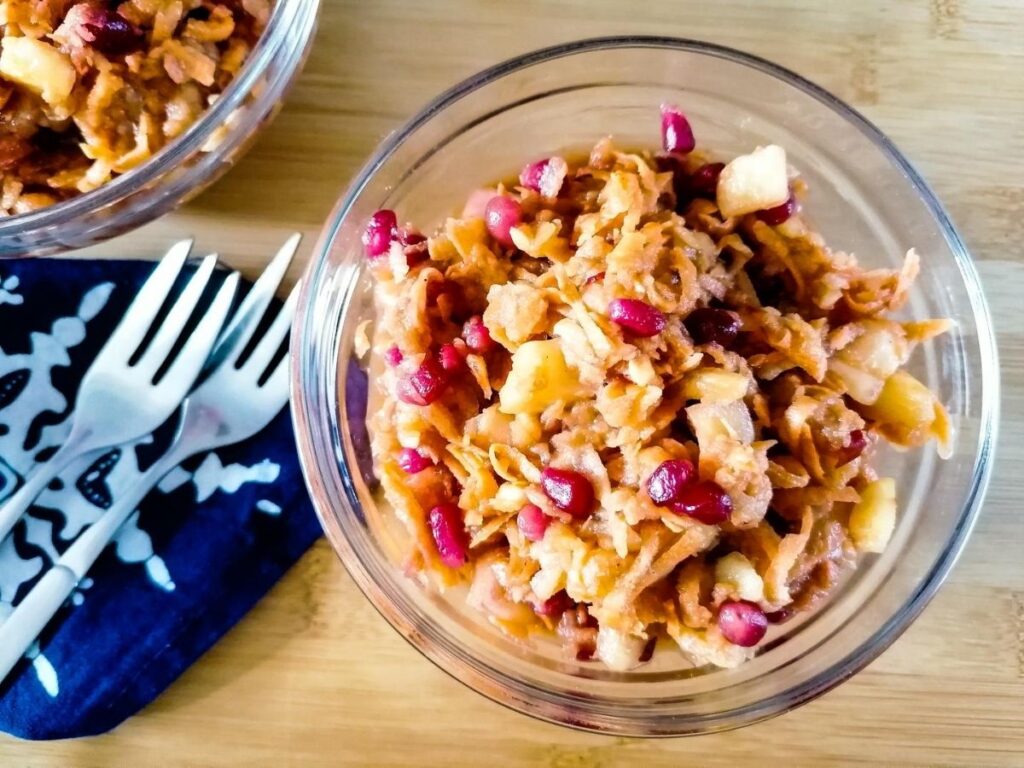 a bowl of Indonesian sweet potato slaw, a blue napkin and two small fork