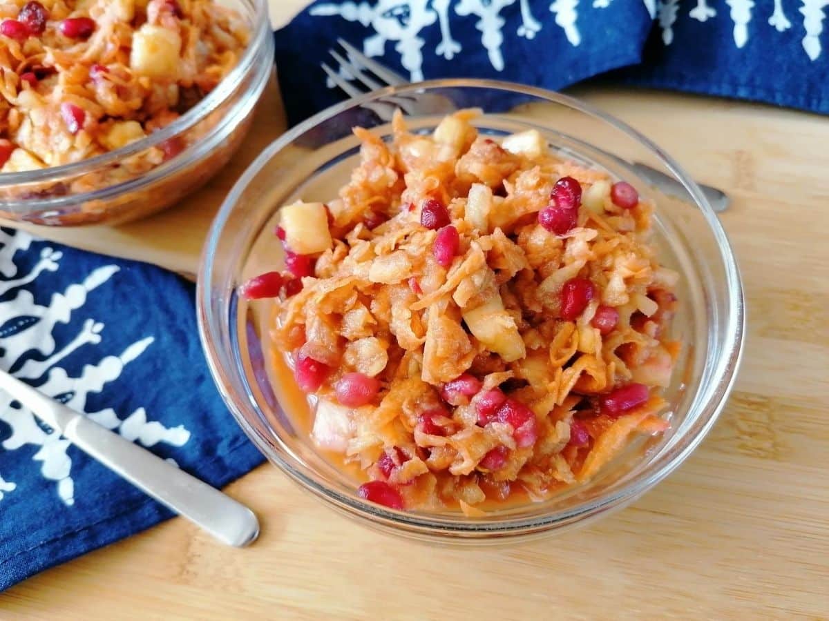 a bowl of Indonesian sweet potato slaw, Rujak Serut, with a blue napkin and a fork