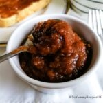 A small bowl of apple jam with a teaspoon over it