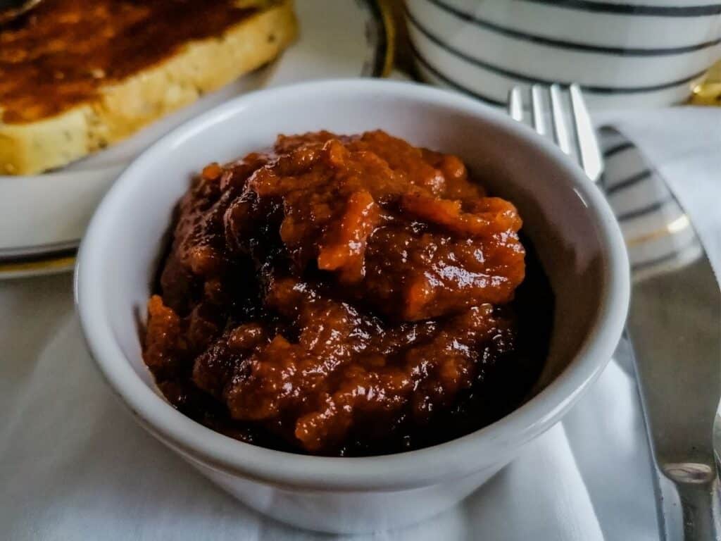a ramekin of apple jam, a toast and a fork