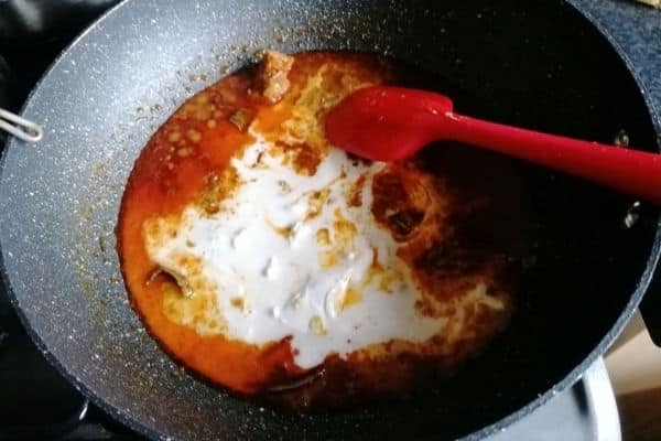 Adding coconut milk to Ayam Suwir Bumbu Bali spices