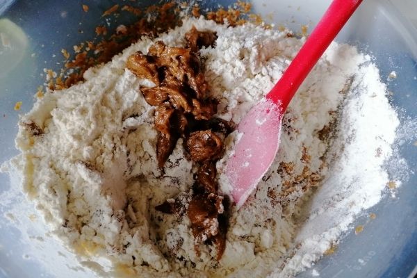 adding flour to the coconut oil with sugar mixture