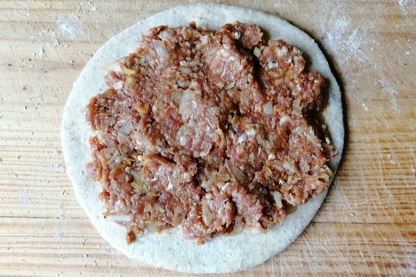 minced meat spread on a rolled out chapati dough