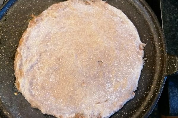 cooking the keema paratha on a flat pan