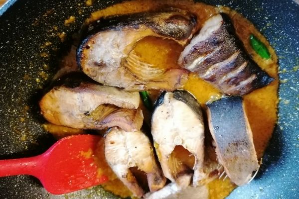 Adding the cooked fish to the spices