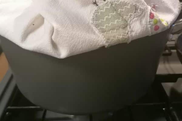 cooking pan with the lid covered with tea towel