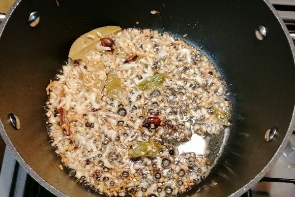 onion and spices being fried on a cooking pan