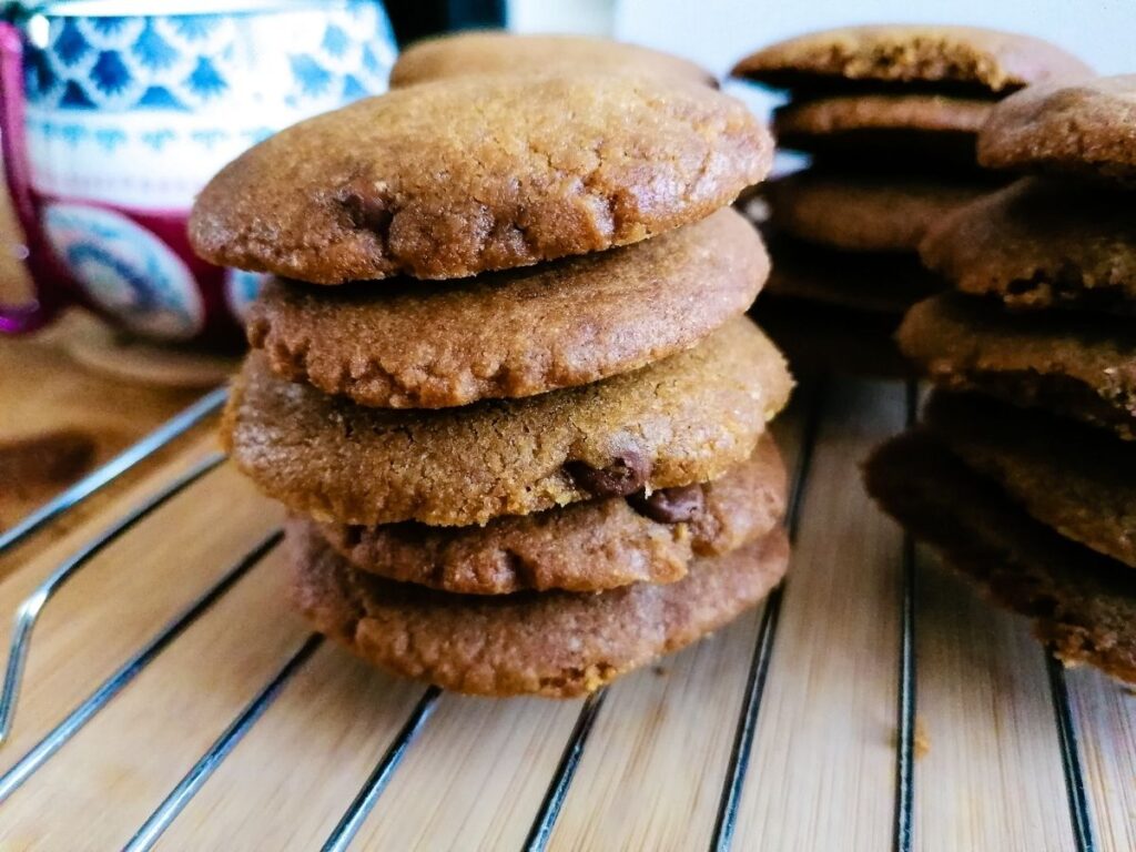 stacked chocolate chip cookies on a cooling rack