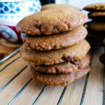 a stack of chocolate chip cookies with coconut oil on a cooling rack