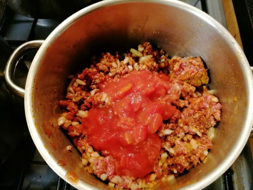 adding chopped tomatoes in lamb minced meat