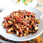 a bowl of dried-anchovies and peanuts in spicy chillies