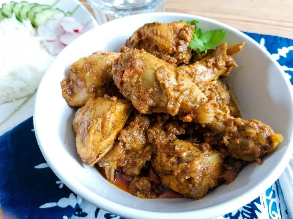 a white bowl of Pakistani chicken karahi