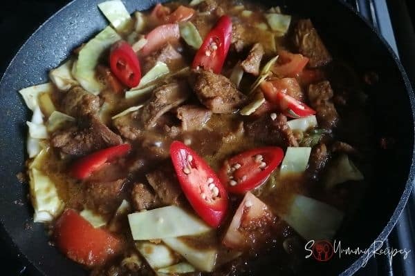 adding chillies and sweet soy sauce to braised lamb