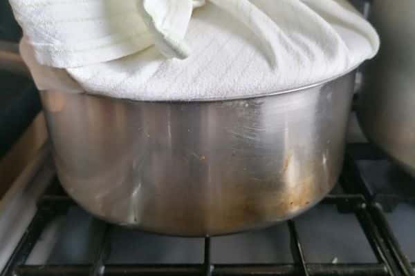cooking pot with the lid covered with a kitchen towel