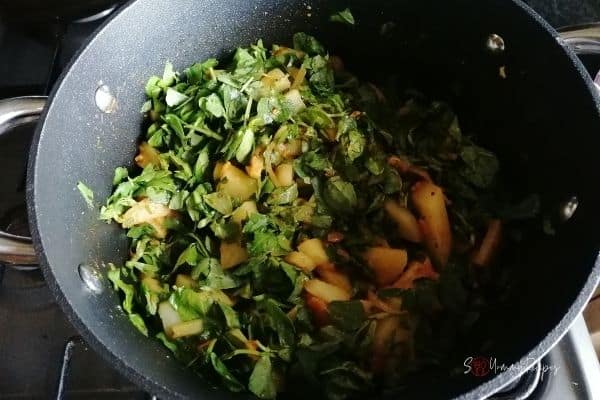 cooking potato curry with fenugreek leaves