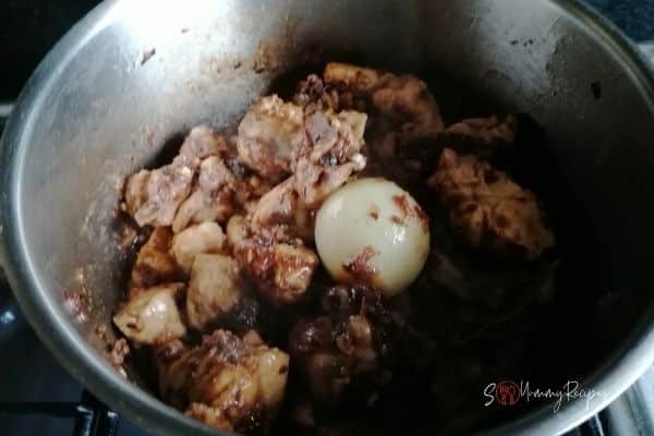 browning the chicken pieces and whole onion in spices