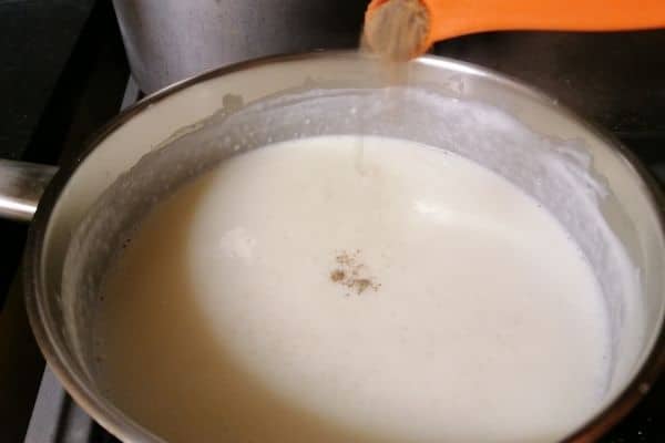 adding cardamom powder to the milk mixture
