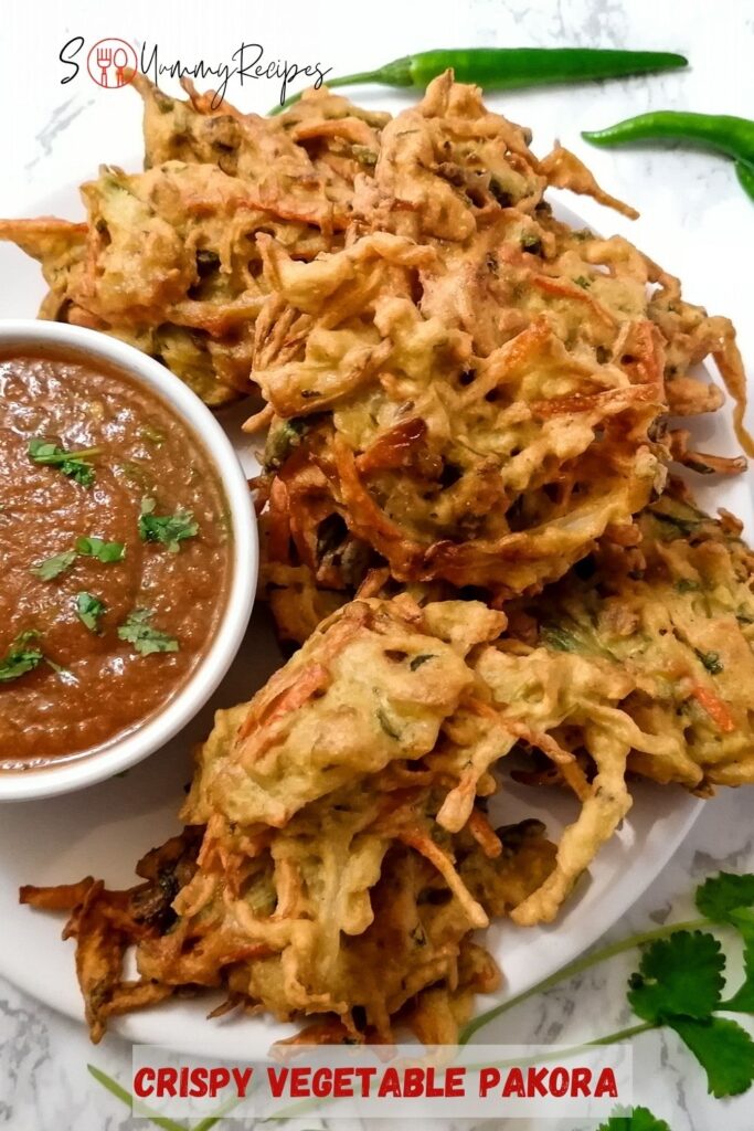 vegetable pakora with a bowl of tomato chutney with overlay text