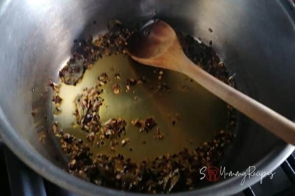 spices and curry leaves sizzling in a pan