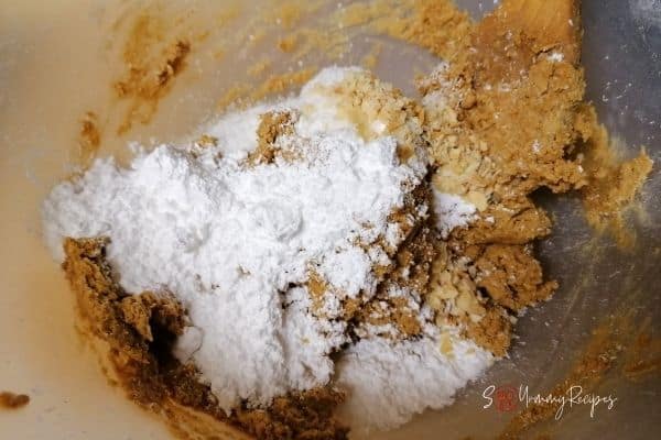 besan flour mixture with desiccated coconut, icing sugar, and chopped nuts