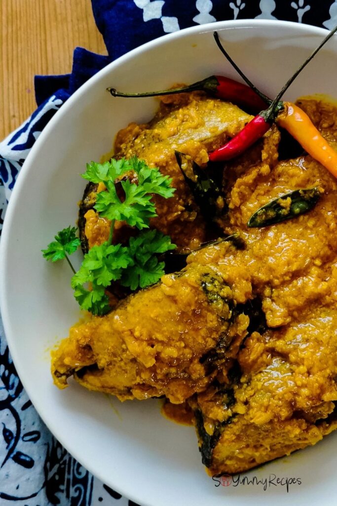 A bowl of Indonesian Ikan Pesmol - the fish in yellow pickle - with chillies and parsley garnish