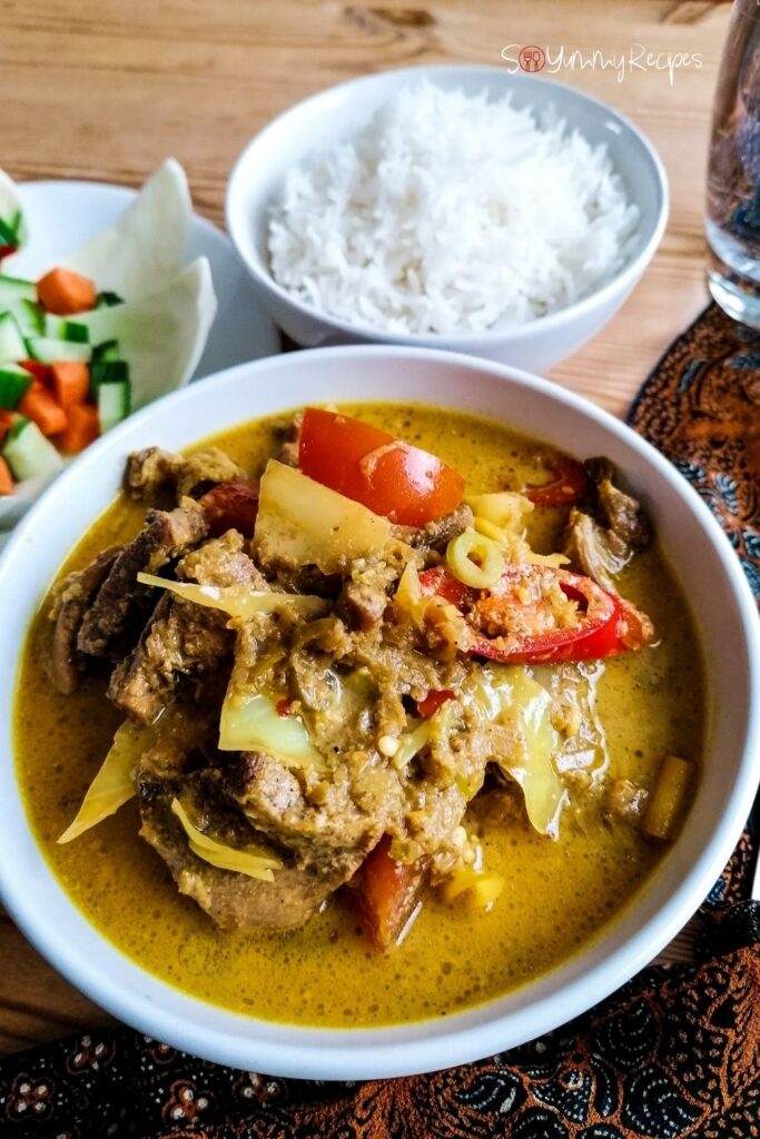 A bowl of Lamb Tongseng - the Indonesian braised lamb in spicy coconut milk with sweet soy sauce , and a bowl of white rice and salad