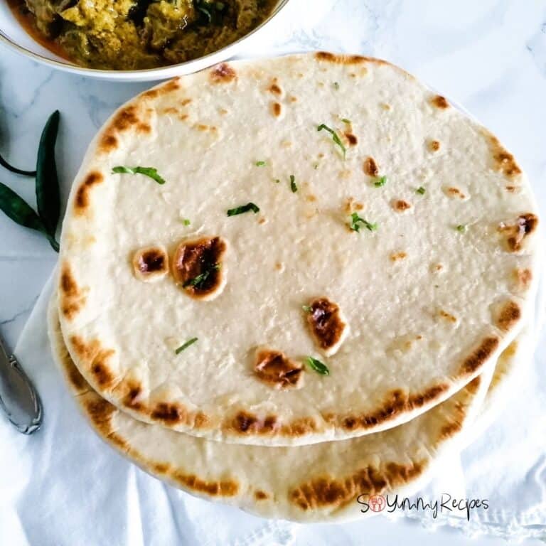 a few naan bread with a few green chillies next to it