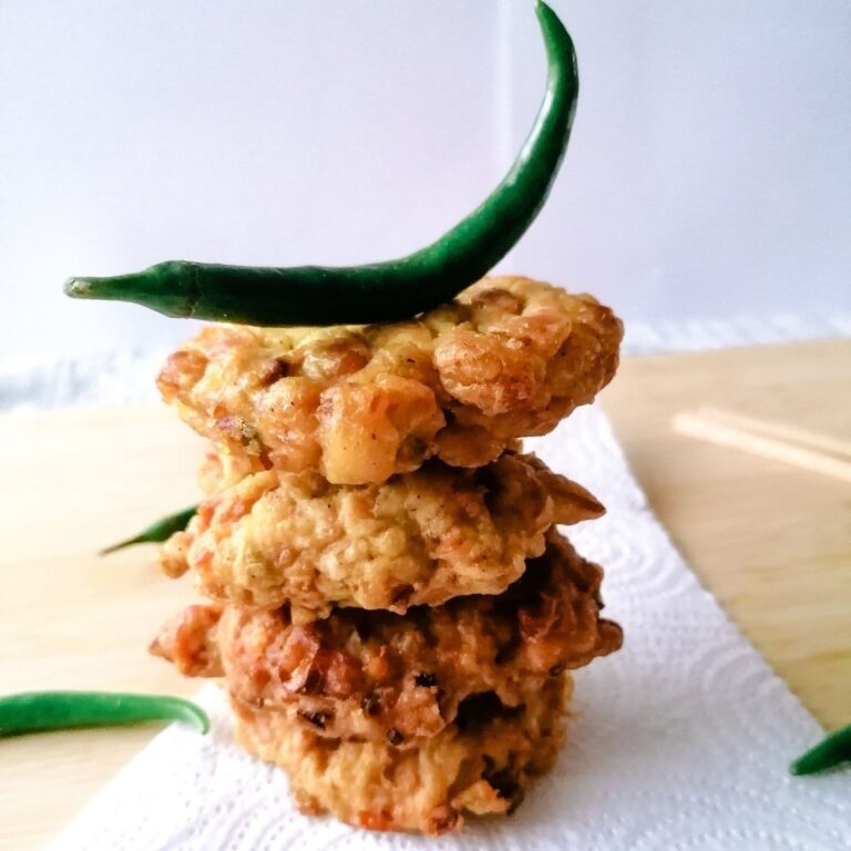 a stack of Perkedel Tempe the Indonesian tempeh fritters with a green chilli on the top