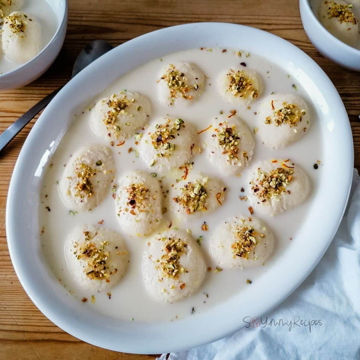 an oval dish of Rasmalai the milk dumpling in fragranced and sweetened milk