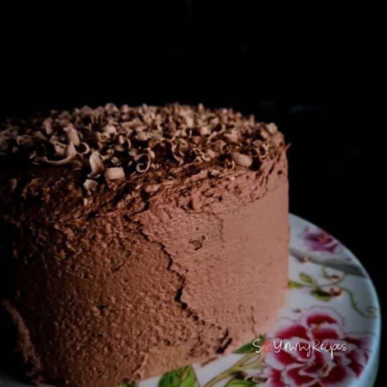 chocolate cake with chocolate mousse frosting on a flower patterned plate