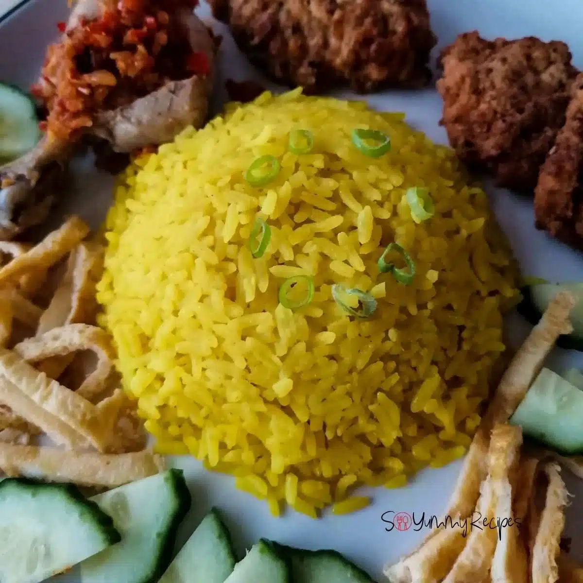 Nasi Kuning - the Indonesian yellow rice with some fritters, chicken, slices of egg omelettes, and cucumber