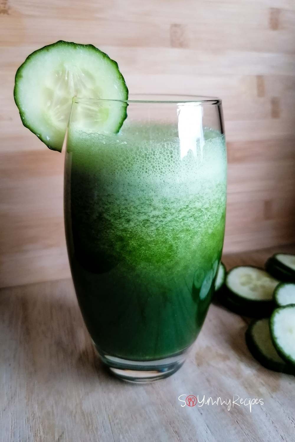 a tall glass of cucumber and kale smoothie with a slice of cucumber