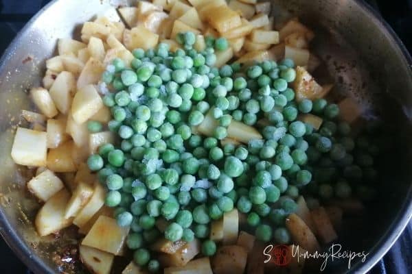 adding the green peas to the potatoes