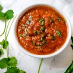 Tomato and chilli chutney Pakistani style with some coriander leaves in the backgound