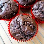 Double chocolate chip muffins in red paper muffin cases.