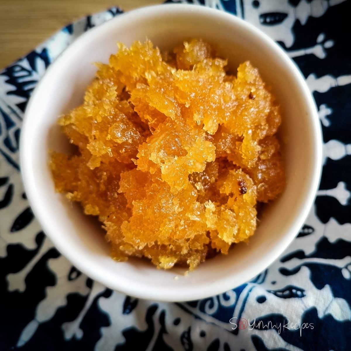 Pineapple jam in a white bowl with blue patterned napkin in the background.