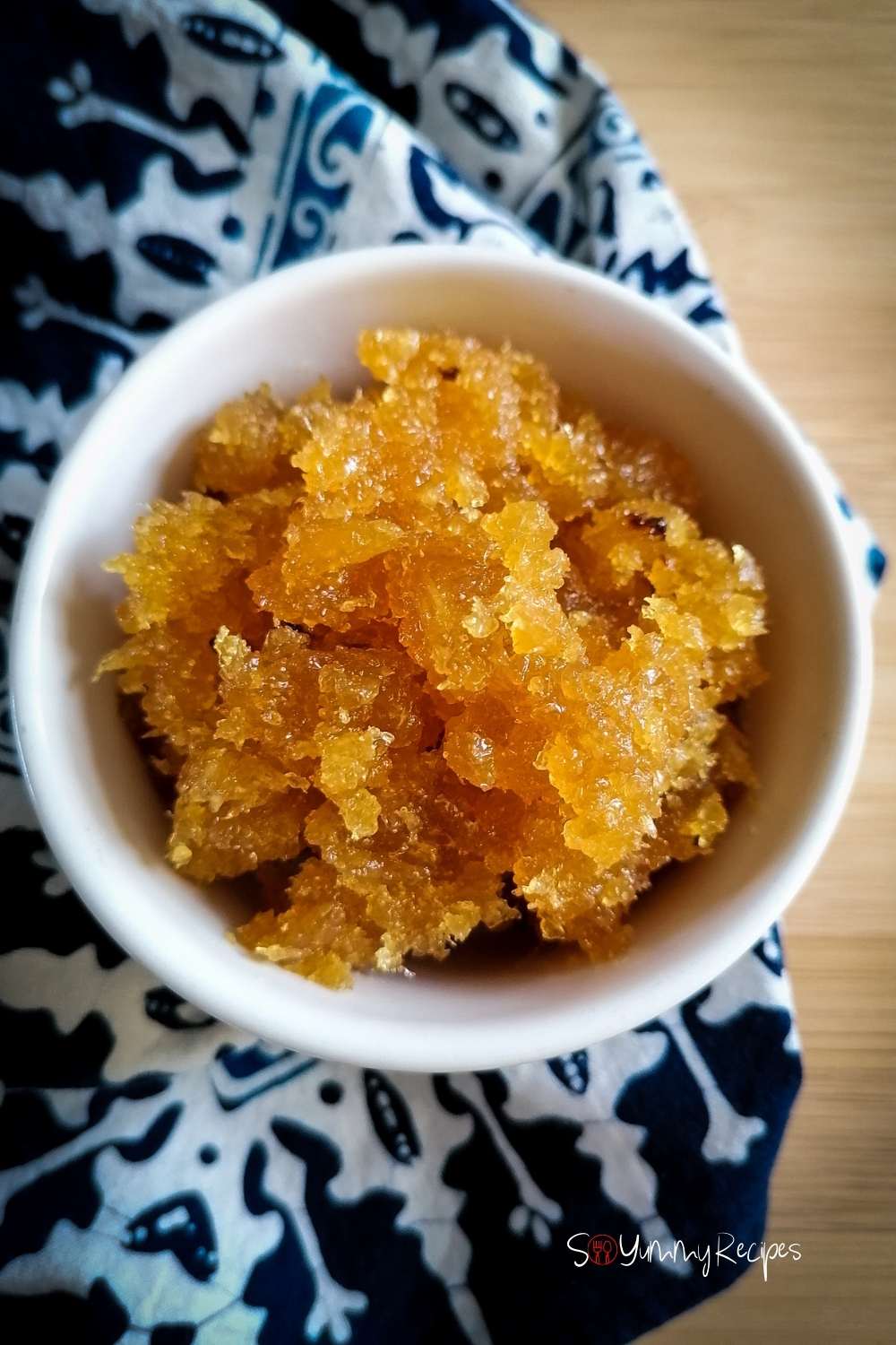 Pineapple jam in a white bowl with blue batik patterned napkin underneath.