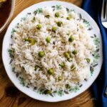 Matar Chawal the Pakistani rice dish with green peas on a round dish.