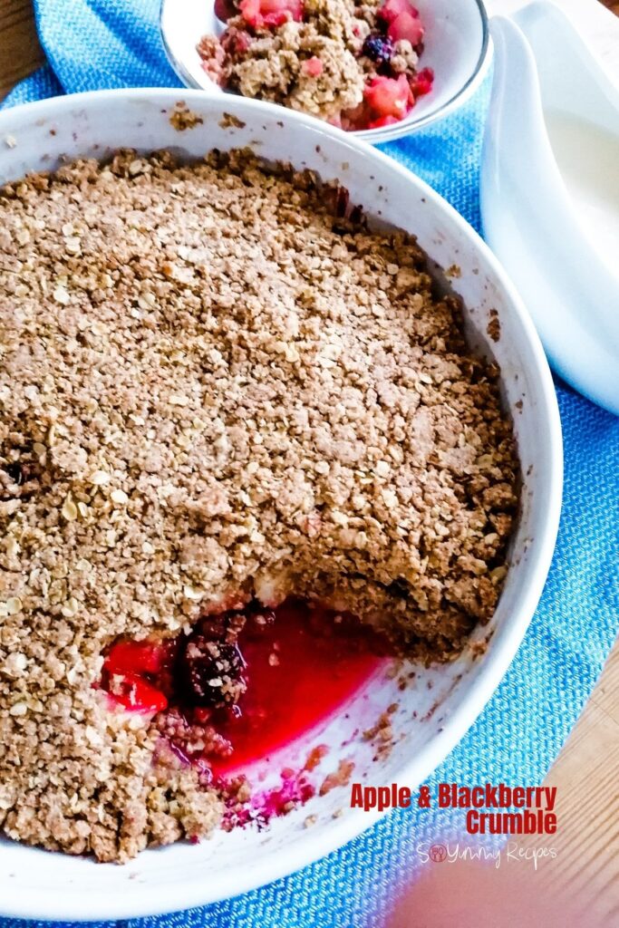Apple and blackberry crumble in a round serving dish.