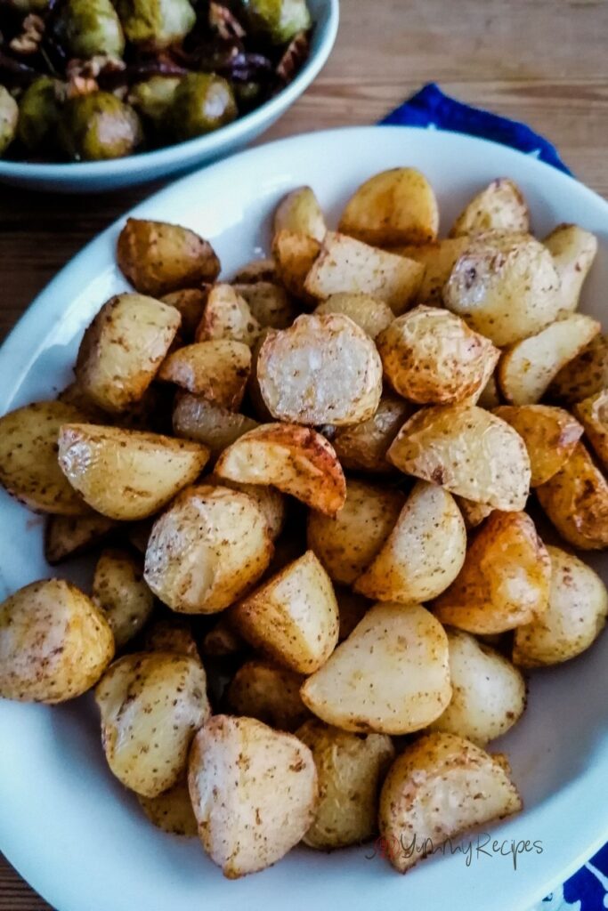Roast potatoes cooked in air fryer on an oval white dish.