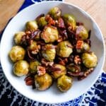 A deep plate of roast Brussels sprouts with honey and balsamic vinegar.