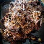 Slow cooked roast lamb shoulder on a roasting tin.